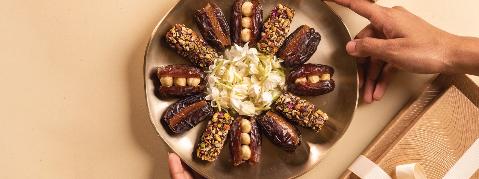 Stuffed dates with nuts and dried fruits as well as date truffles on a decorative platter for serving guests