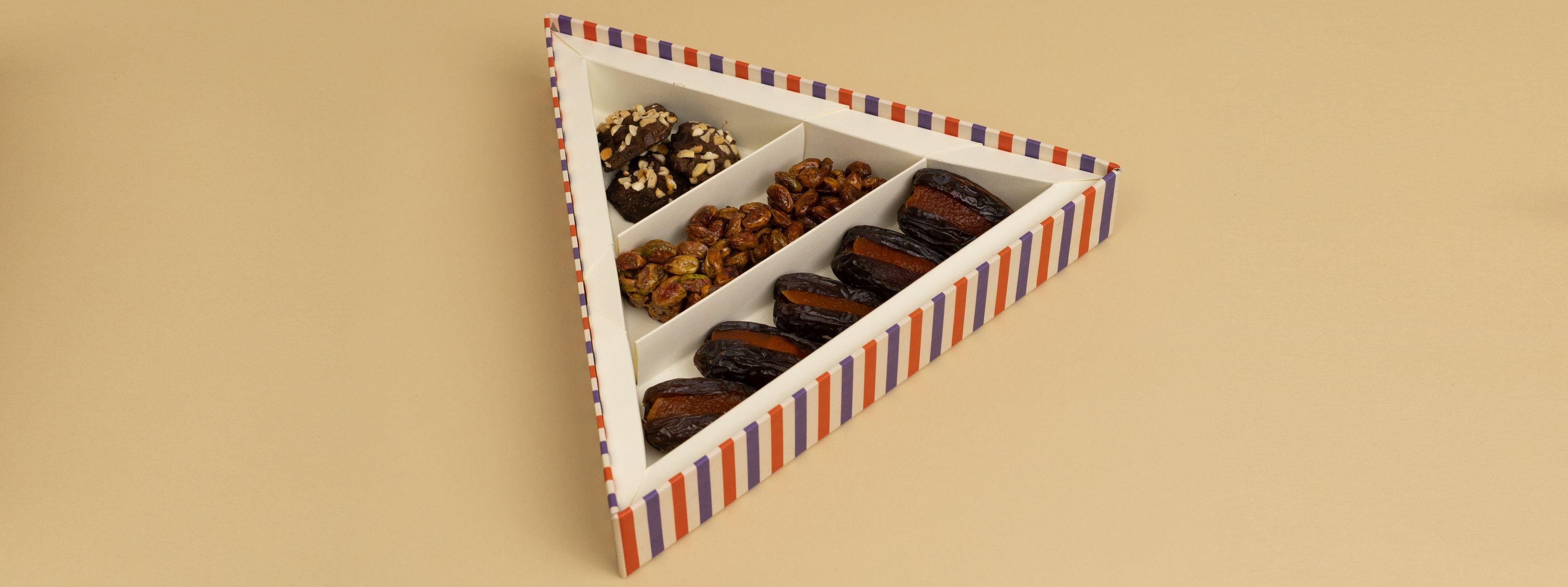 triangle box that contains stuffed dates, honey and nut clusters, chocolate rocks