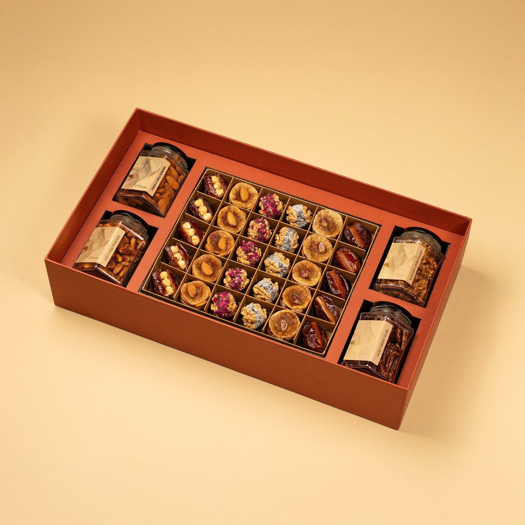 A large gift box that holds four large jars and 30 pieces of dried fruit like stuffed dates, figs and truffles