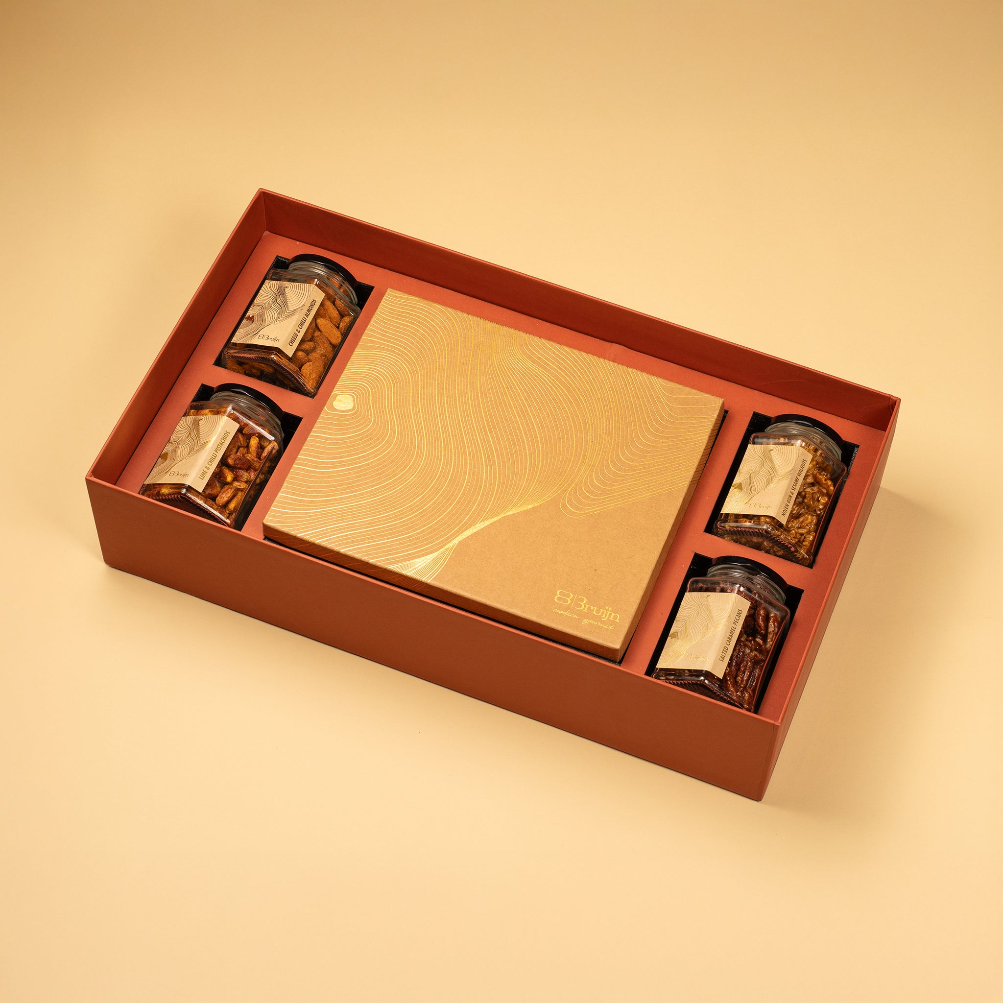 A large gift box that holds four large jars and 30 pieces of dried fruit like stuffed dates, figs and truffles