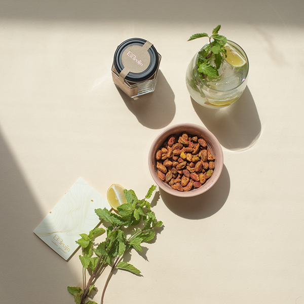Roasted pistachio kernels flavoured with chilli and lime accompanying a light summer drink