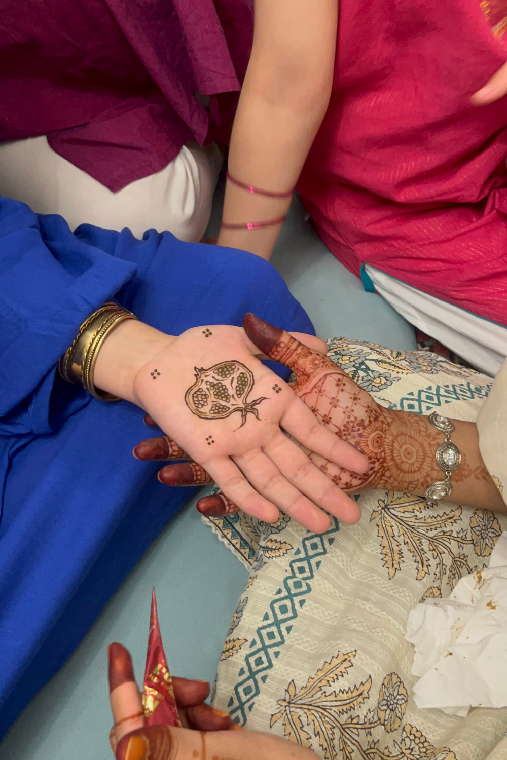 Two hands with intricate henna design showcasing a pomegranate which is sacred to Persian identity