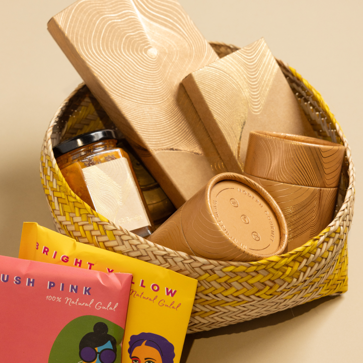 A basket containing various food items including packaged snacks and a decorative item, set against a neutral background.