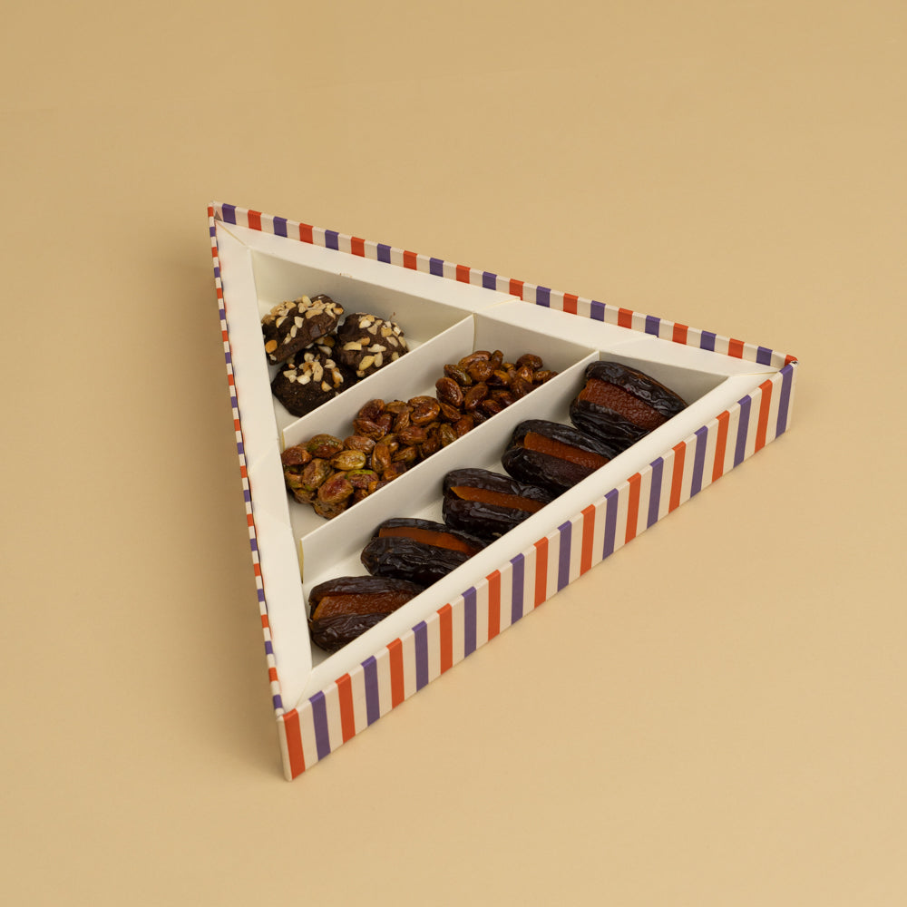 A triangle box that contains stuffed dates, honey and nut clusters, chocolate rocks