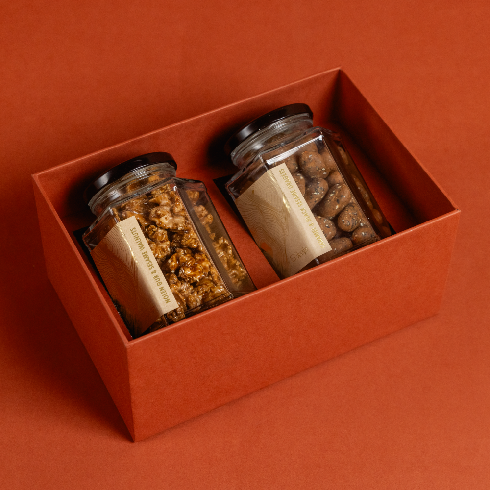 A gift box that holds large jars with caramelised walnuts and white chocolate almond dragees