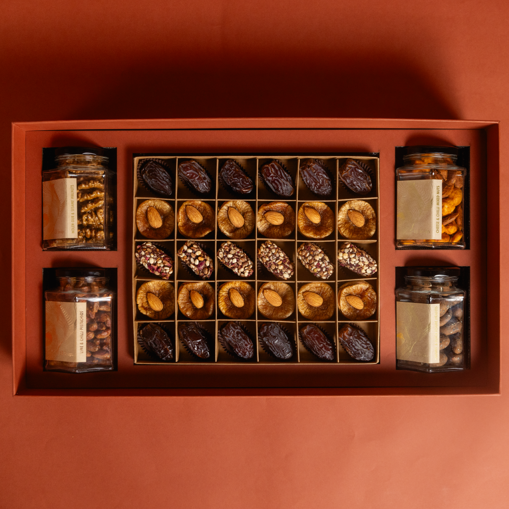 A large gift box that holds four large jars and 30 pieces of dried fruit like stuffed dates, figs and truffles