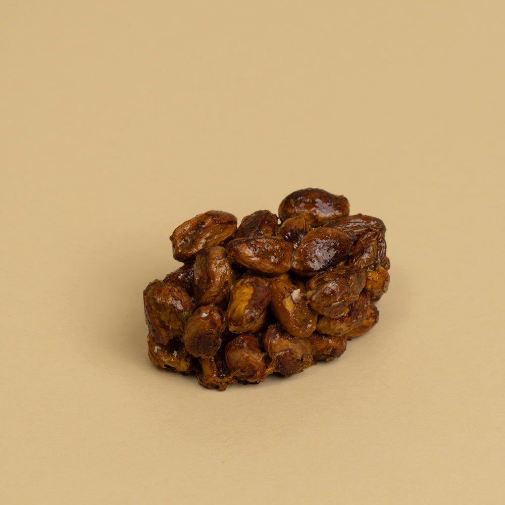 Cluster of pistachio bound by honey on a beige background