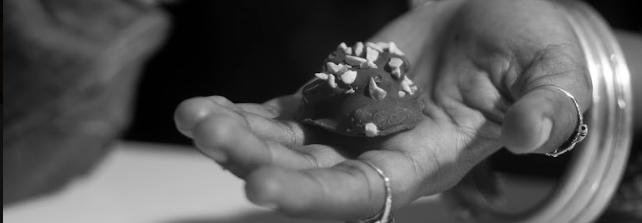 Close-up of a hand holding a chocolate with a blurred background