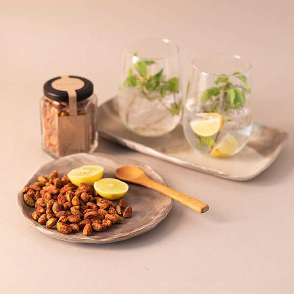 Roasted pistachio kernels flavoured with chilli and lime accompanying a light summer drink