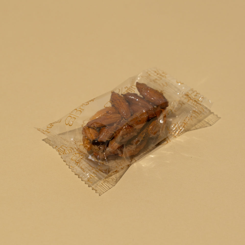 Hand holding a plastic packing of almond and honey cluster