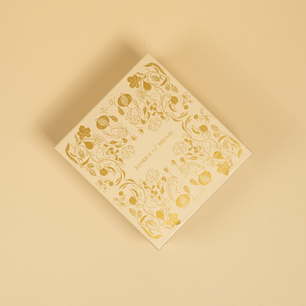 Decorative box with gold floral patterns on a beige background