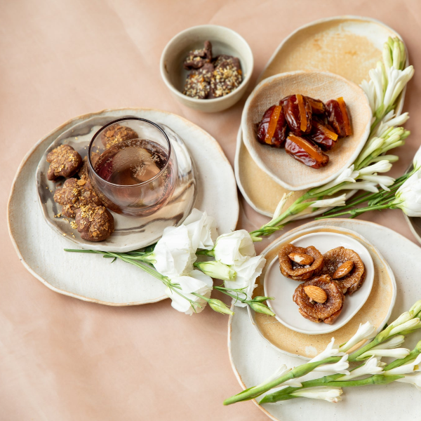 Dessert platter with cookies, dates, and a glass of tea 