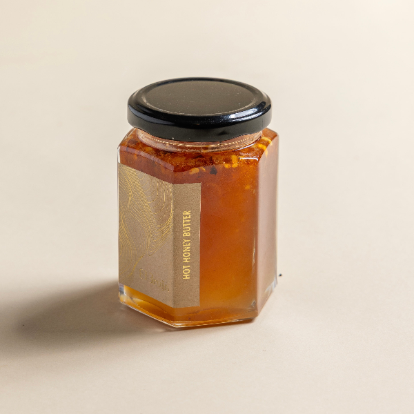 A jar of Hot Honey Butter. The 200ml jar is filled with a honey butter mix.