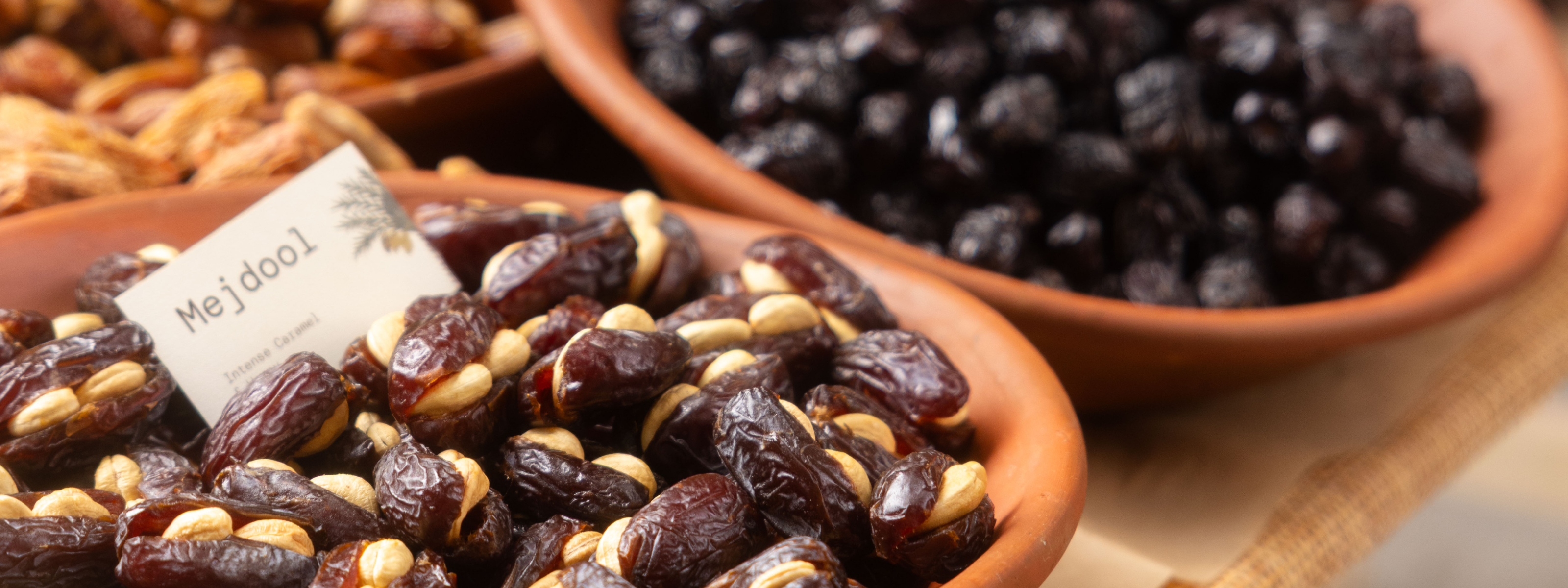Dried fruits like stuffed dates with cashews in terracotta bowls