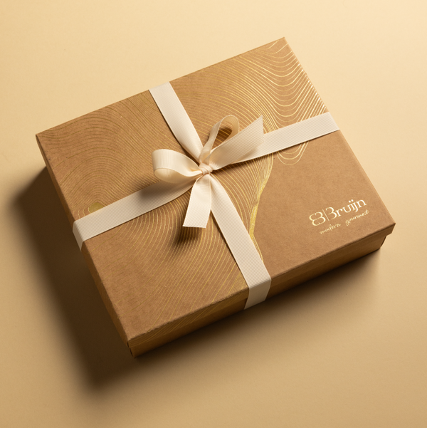 Brown gift box with a white ribbon on a beige background