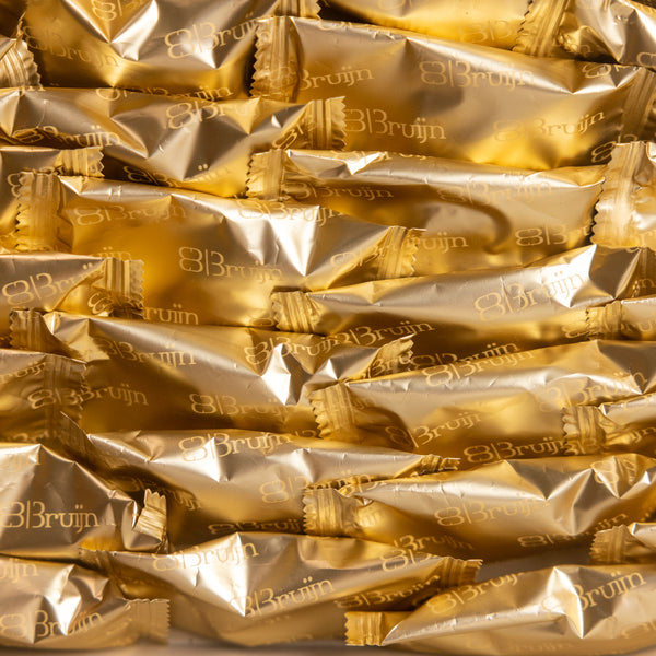 Close-up of Bruijn golden-wrapped Medjool dates arranged in a reusable tray.