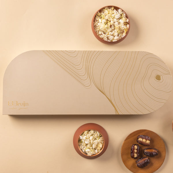 Flatlay of Signature Tray box with bowls of jasmine flowers and Bruijn dates around it.
