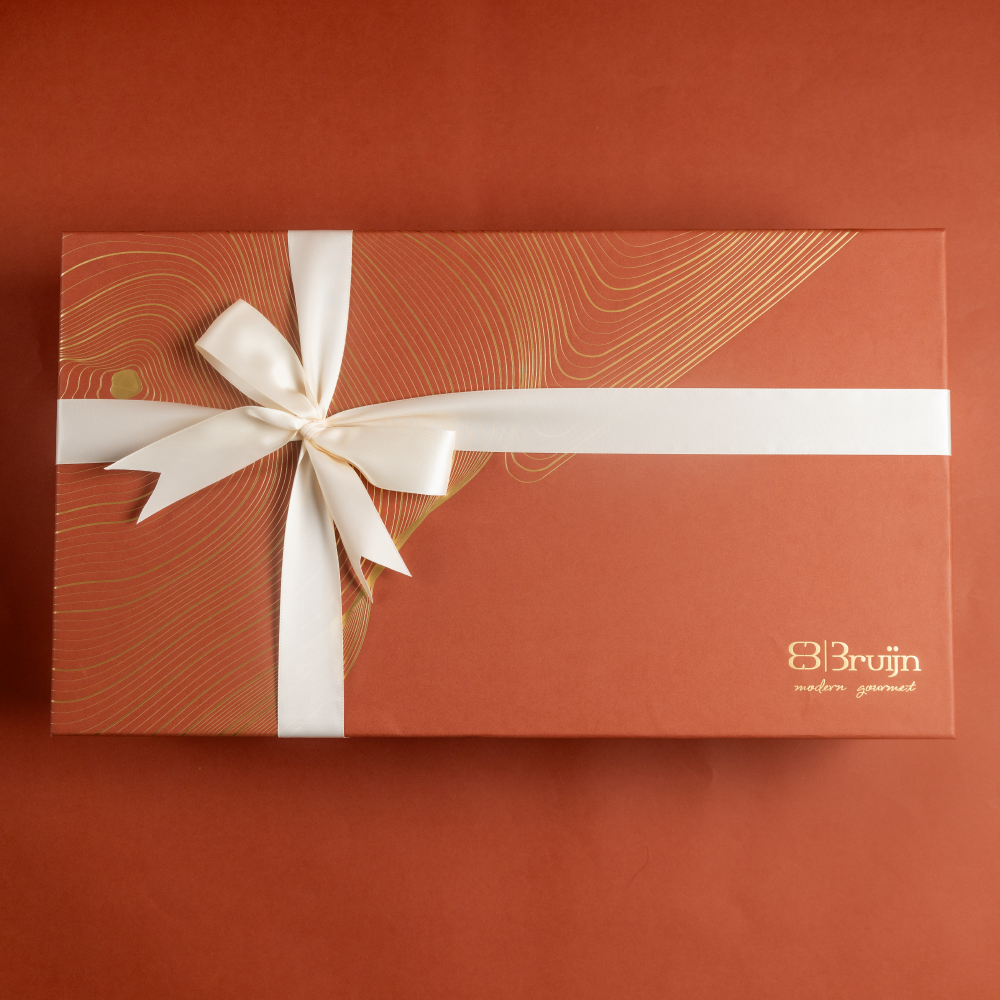 A large gift box that holds four large jars and 30 pieces of dried fruit like stuffed dates, figs and truffles