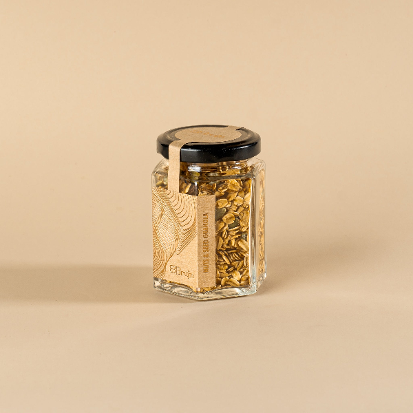 A glass jar filled with nuts and seed granola.
